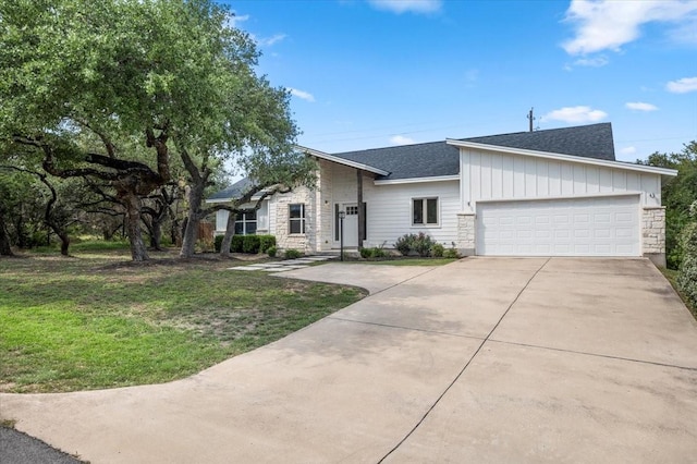15202 Cavalier Canyon Dr, Lakeway, TX 78734 - view of front of home featuring concrete driveway, a shingled roof, a garage, and a front yard