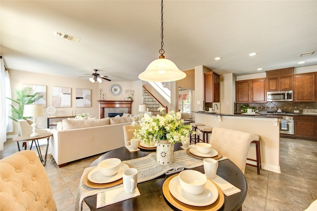 27107 Downing Park Blvd, Katy, TX 77494 - dining room featuring stairs, a ceiling fan, recessed lighting, light tile patterned flooring, and a fireplace