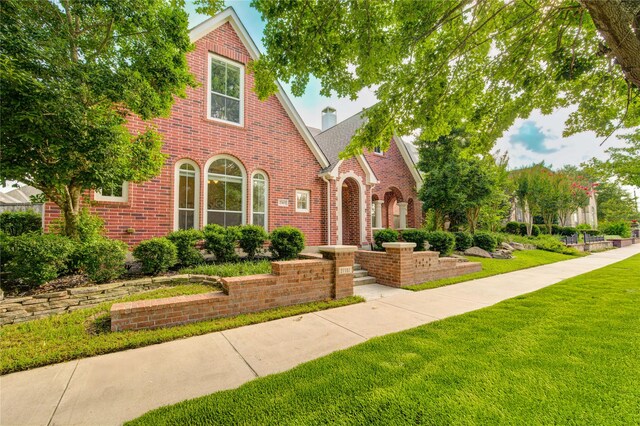 27107 Downing Park Blvd, Katy, TX 77494 - english style home featuring brick siding, a front lawn, a chimney, and roof with shingles