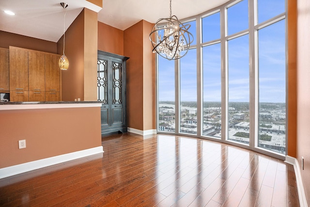 4821 Nasa Pkwy Unit 12E, Pasadena, TX 77586 - unfurnished dining area with a wall of windows, dark wood finished floors, baseboards, and a chandelier