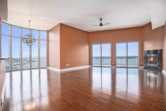 4821 Nasa Pkwy Unit 12E, Pasadena, TX 77586 - unfurnished living room with plenty of natural light, a chandelier, expansive windows, a ceiling fan, and wood finished floors