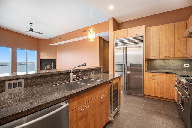 4821 Nasa Pkwy Unit 12E, Pasadena, TX 77586 - kitchen with high quality appliances, a sink, a ceiling fan, beverage cooler, and a lit fireplace