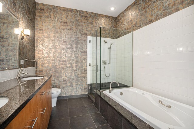 4821 Nasa Pkwy Unit 12E, Pasadena, TX 77586 - full bathroom featuring a stall shower, double vanity, a garden tub, tile patterned floors, and toilet