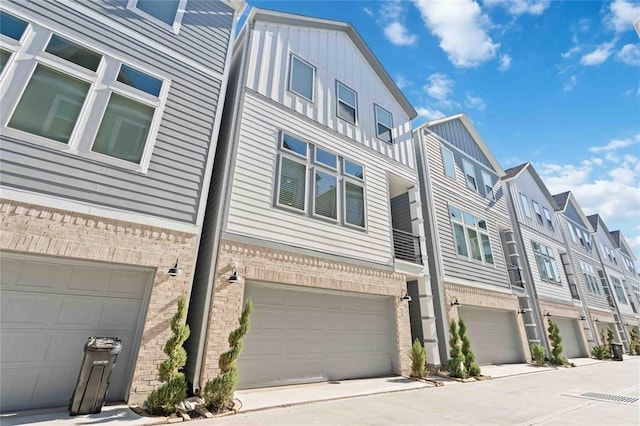 622 Janisch Rd Unit F, Houston, TX 77018 - view of property exterior with a residential view, a garage, brick siding, and board and batten siding