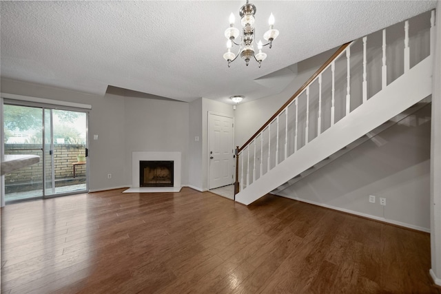 2120 El Paseo St Unit 2901, Houston, TX 77054 - unfurnished living room featuring a textured ceiling, wood finished floors, a chandelier, a fireplace with flush hearth, and baseboards