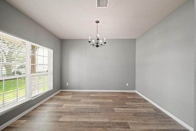 12414 Village Of Kings Lake Blvd, Houston, TX 77044 - unfurnished room featuring a chandelier, plenty of natural light, light wood-style flooring, and baseboards