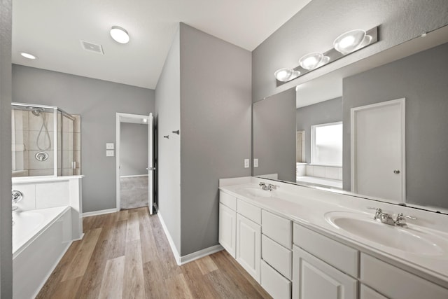 12414 Village Of Kings Lake Blvd, Houston, TX 77044 - bathroom with a garden tub, double vanity, wood finished floors, a stall shower, and baseboards