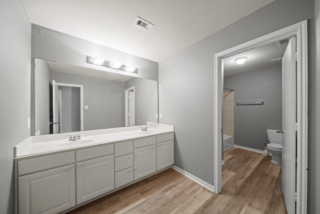 12414 Village Of Kings Lake Blvd, Houston, TX 77044 - bathroom with double vanity, toilet, wood finished floors, baseboards, and bathtub / shower combination