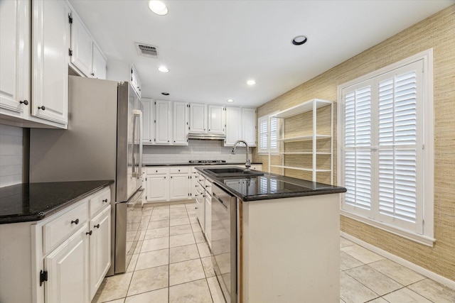 1984 Indiana St, Houston, TX 77019 - kitchen featuring a sink, light tile patterned flooring, stainless steel appliances, a kitchen island with sink, and white cabinetry
