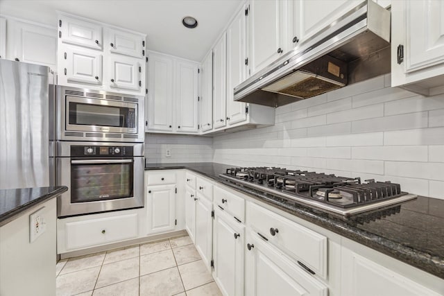 1984 Indiana St, Houston, TX 77019 - kitchen with stainless steel appliances, extractor fan, white cabinets, and decorative backsplash
