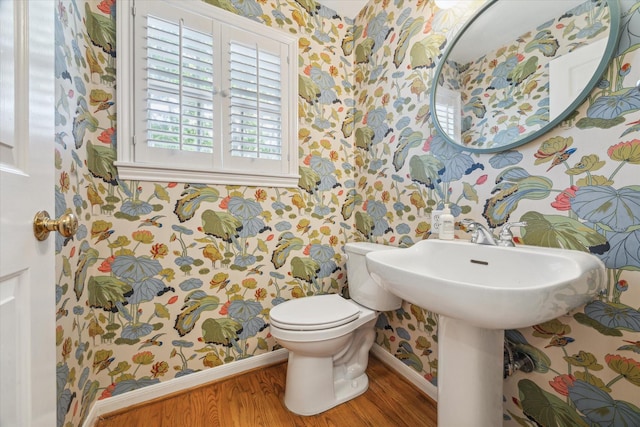 1984 Indiana St, Houston, TX 77019 - half bathroom featuring wallpapered walls, baseboards, wood finished floors, and toilet