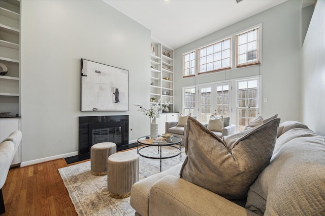 1984 Indiana St, Houston, TX 77019 - living area featuring built in features, a fireplace with flush hearth, wood finished floors, and a high ceiling