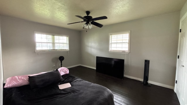 4400 Bethany St, Port Arthur, TX 77642 - bedroom featuring multiple windows, baseboards, dark wood-style flooring, a textured ceiling, and ceiling fan