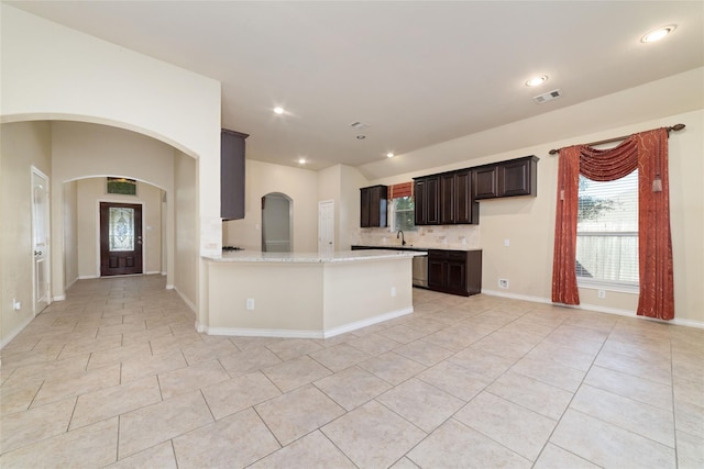 6230 Borg Breakpoint Dr, Spring, TX 77379 - kitchen with light tile patterned floors, stainless steel dishwasher, a sink, tasteful backsplash, and dark brown cabinetry
