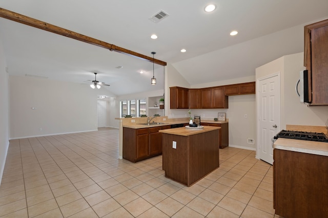 6806 Kotlan Ct, Magnolia, TX 77354 - kitchen featuring vaulted ceiling, light tile patterned flooring, open floor plan, a sink, and baseboards