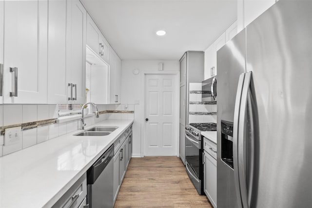 710 Vashti Dr, Houston, TX 77037 - kitchen featuring appliances with stainless steel finishes, a sink, decorative backsplash, light wood-style floors, and light countertops
