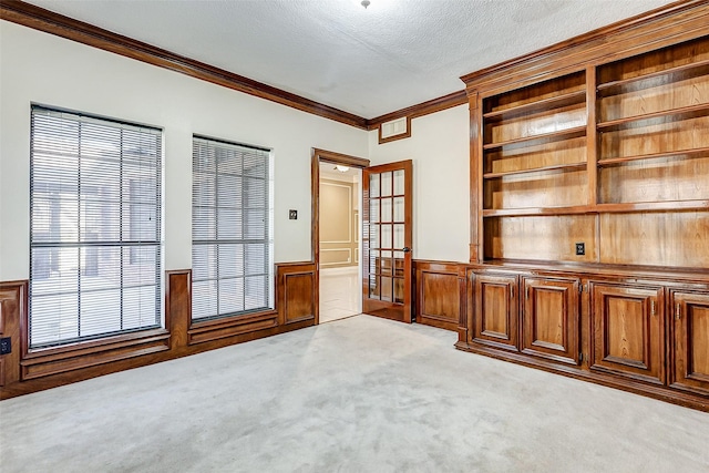 5802 Ashmere Ln, Spring, TX 77379 - carpeted spare room with a wainscoted wall, crown molding, a textured ceiling, and french doors