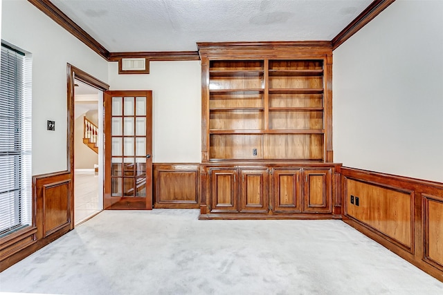 5802 Ashmere Ln, Spring, TX 77379 - carpeted empty room with crown molding, wainscoting, french doors, and a textured ceiling