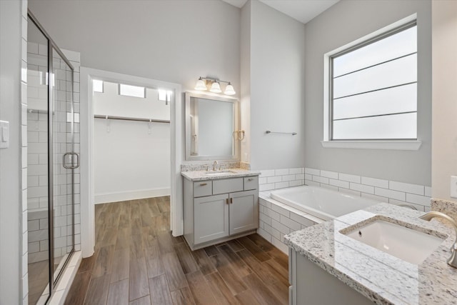 5405 Larkin St, Houston, TX 77007 - full bathroom featuring two vanities, a stall shower, a bath, and wood finished floors