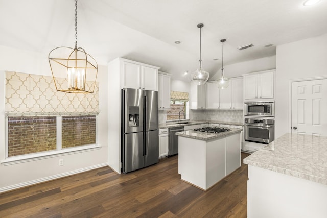 10906 Bernalda Cir, Richmond, TX 77406 - kitchen featuring appliances with stainless steel finishes, a sink, a center island, lofted ceiling, and tasteful backsplash