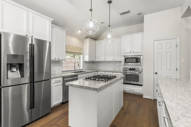 10906 Bernalda Cir, Richmond, TX 77406 - kitchen with stainless steel appliances, lofted ceiling, decorative backsplash, white cabinetry, and light stone counters