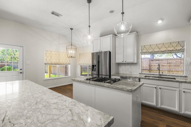 10906 Bernalda Cir, Richmond, TX 77406 - kitchen featuring appliances with stainless steel finishes, a sink, a kitchen island, vaulted ceiling, and dark wood finished floors