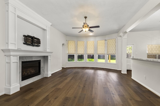10906 Bernalda Cir, Richmond, TX 77406 - unfurnished living room with a ceiling fan, dark wood-style floors, a fireplace, baseboards, and ornate columns