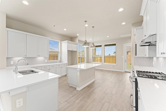 2218 Elm Rdg, Tomball, TX 77375 - kitchen featuring gas stove, a sink, under cabinet range hood, recessed lighting, and baseboards