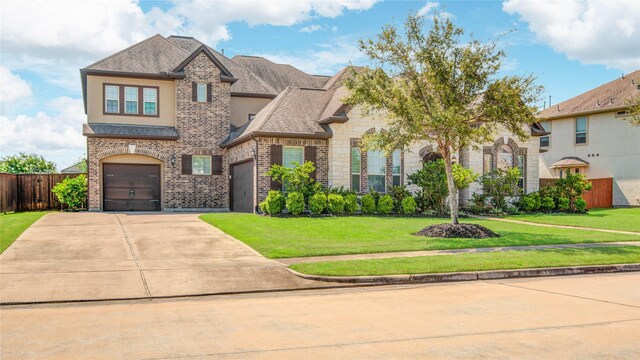 2515 Rainflower Meadow Ln, Katy, TX 77494 - view of front of house featuring concrete driveway, brick siding, stone siding, and roof with shingles