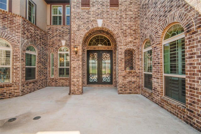 2515 Rainflower Meadow Ln, Katy, TX 77494 - view of exterior entry featuring brick siding, a patio, and french doors
