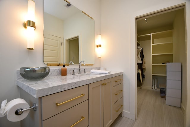 802 W 30th St, Houston, TX 77018 - bathroom featuring vanity, a spacious closet, and baseboards