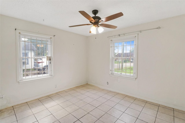 7547 Touchstone St, Houston, TX 77028 - spare room featuring ceiling fan, a textured ceiling, light tile patterned floors, and baseboards