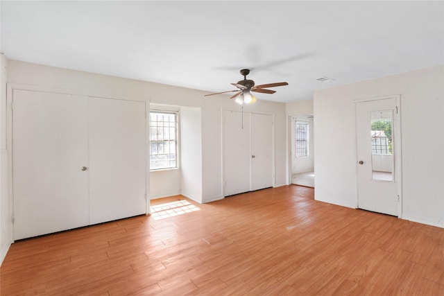 7547 Touchstone St, Houston, TX 77028 - unfurnished bedroom featuring multiple closets, multiple windows, light wood-type flooring, and a ceiling fan