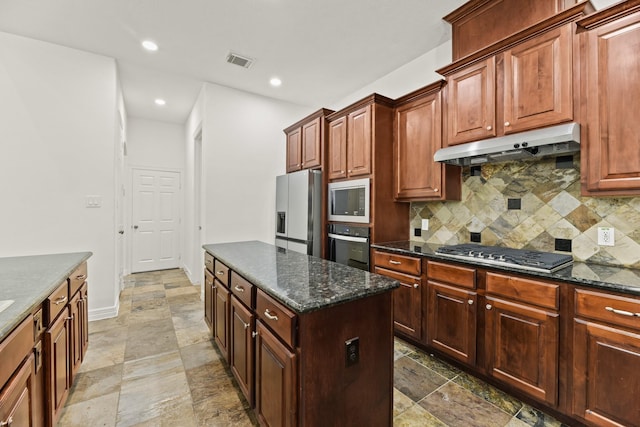 512 Cherry Hills Dr, Huntsville, TX 77340 - kitchen with stainless steel appliances, under cabinet range hood, stone tile flooring, tasteful backsplash, and recessed lighting