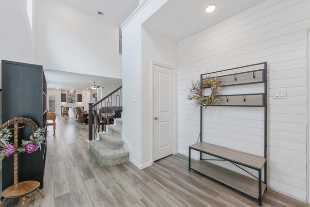 15511 Bosque Valley Ct, Cypress, TX 77433 - hallway with a high ceiling, wooden walls, stairs, and wood finished floors