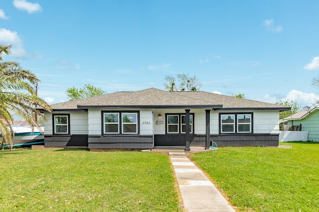 1502 W 9th St, Freeport, TX 77541 - view of front of house with a shingled roof, a front yard, and covered porch
