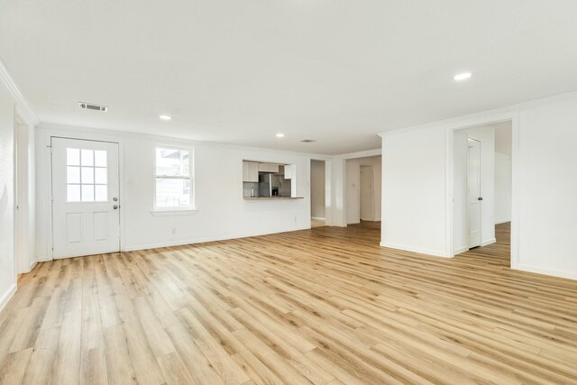 1502 W 9th St, Freeport, TX 77541 - unfurnished living room featuring crown molding, light wood-type flooring, recessed lighting, and baseboards