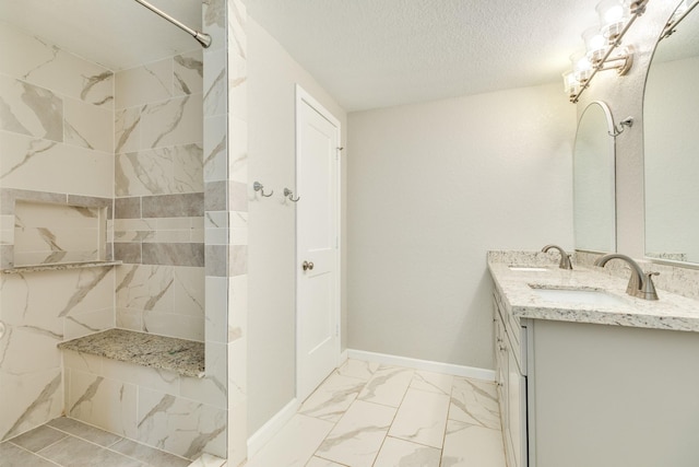 1502 W 9th St, Freeport, TX 77541 - full bath featuring double vanity, a tile shower, marble finish flooring, baseboards, and a textured ceiling
