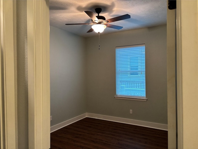 943 Sand Dune Dr, Crystal Beach, TX 77650 - empty room with dark wood-style flooring, baseboards, a textured ceiling, and ceiling fan