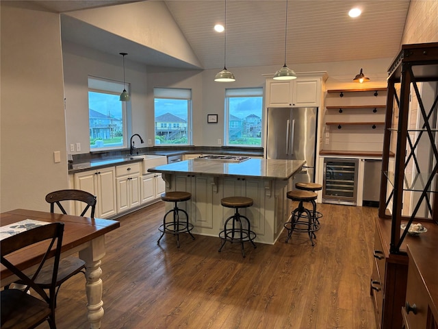 943 Sand Dune Dr, Crystal Beach, TX 77650 - kitchen with wine cooler, appliances with stainless steel finishes, a sink, a kitchen bar, and white cabinets