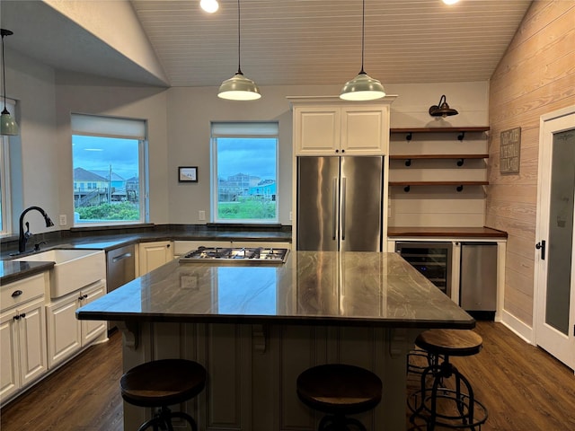 943 Sand Dune Dr, Crystal Beach, TX 77650 - kitchen featuring appliances with stainless steel finishes, lofted ceiling, a sink, dark wood-type flooring, and wooden walls