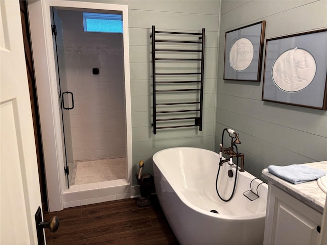 943 Sand Dune Dr, Crystal Beach, TX 77650 - bathroom featuring radiator, wood finished floors, a stall shower, and a freestanding tub