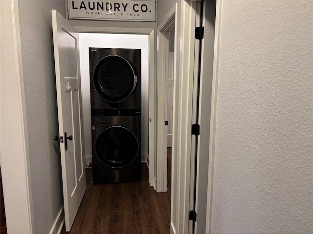 943 Sand Dune Dr, Crystal Beach, TX 77650 - laundry room featuring estacked washer and dryer, dark wood-style flooring, and a textured wall