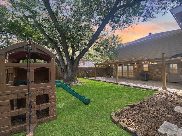 1927 Willowlake Dr, Houston, TX 77077 - yard at dusk with a playground, a patio, and central AC