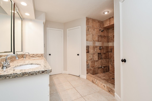 1927 Willowlake Dr, Houston, TX 77077 - bathroom featuring double vanity, tile patterned floors, tiled shower, recessed lighting, and baseboards
