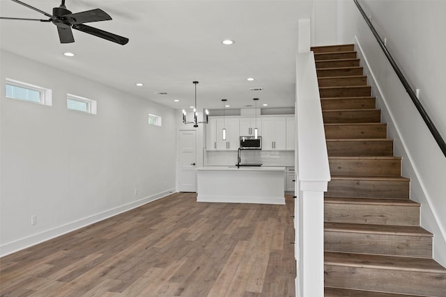 8417 Venus St Unit A B, Houston, TX 77088 - stairway with recessed lighting, a ceiling fan, wood finished floors, baseboards, and a chandelier