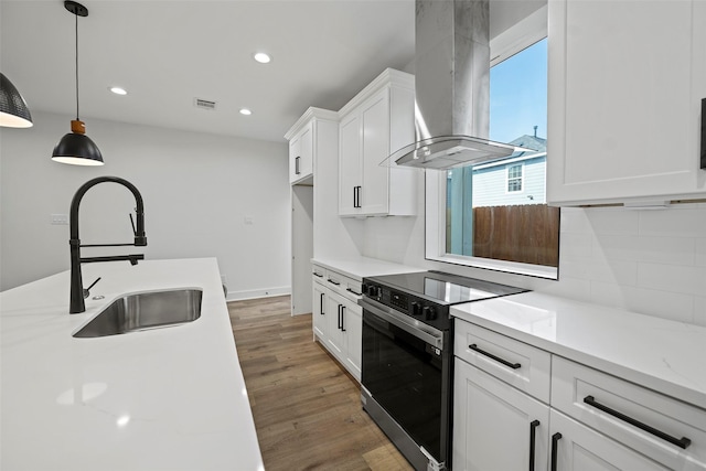 8417 Venus St Unit A B, Houston, TX 77088 - kitchen featuring wall chimney range hood, black range with electric stovetop, a sink, white cabinets, and light countertops