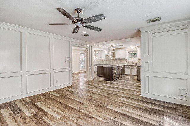 12906 Ivyforest Dr, Cypress, TX 77429 - unfurnished living room featuring a decorative wall, a ceiling fan, light wood-style floors, and recessed lighting