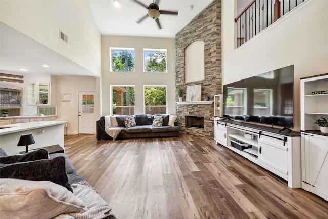 14619 Hampton Green Ln, Houston, TX 77044 - living area with high vaulted ceiling, a ceiling fan, wood finished floors, and a fireplace