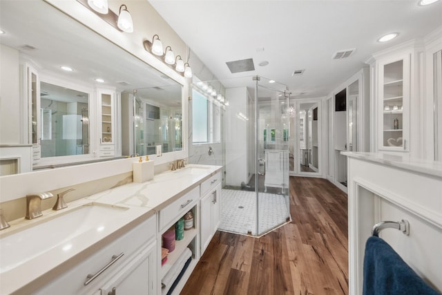 14619 Hampton Green Ln, Houston, TX 77044 - bathroom featuring wood finished floors, a stall shower, double vanity, a skylight, and recessed lighting